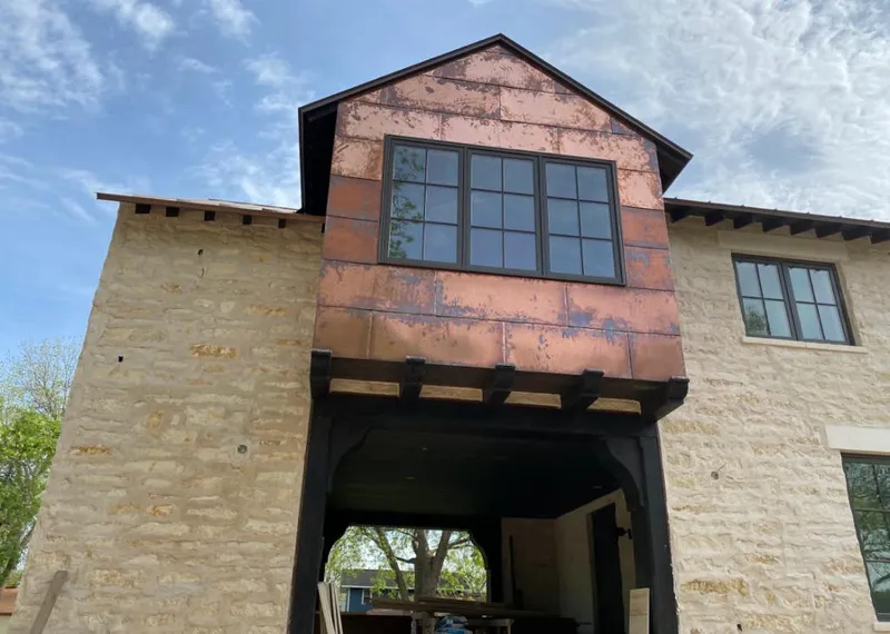 Copper metal panel facade on a stone building for Roof Repair in Kirtland