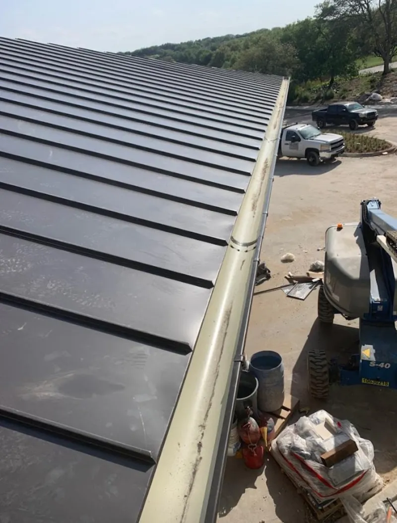 Standing seam panel and gutter detail on a metal roofing jobsite in Kirtland